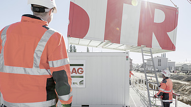 Photo Two men back view watching container elevation