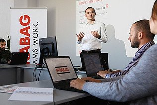 Photo Man presenting with both hands in a seminar room