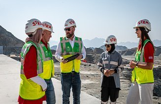 Kolleg:innen stehen zusammen auf der Baustelle im Oman