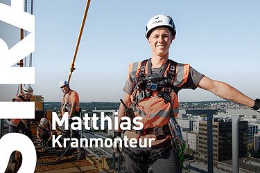 Mann in STRABAG-Arbeitskleidung steht auf einer Baustelle und blickt in die Ferne.