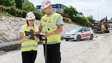 Zdjęcie kobiety i mężczyzny podczas prac geodezyjnych 