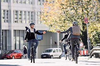 Two cyclists meet on the road on their company bike