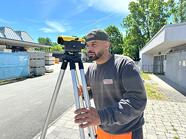 Kazim, Auszubildender im Straßenbau mit Messgerät