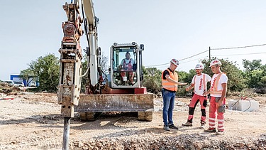 Kolega Ante pokazuje drugim kolegama rupu na gradilištu