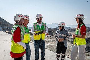 Kolleg:innen stehen zusammen auf der Baustelle im Oman