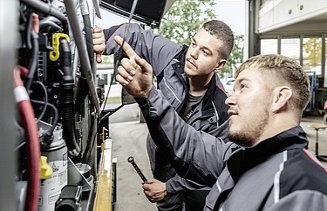 Foto Zwei Männer arbeiten bei einem Gerät der vordere zeigt hinauf