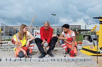 Mladić na gradilištu gleda u kameru