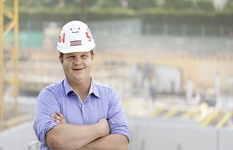 Photo man with folded arms and helmet on construction site