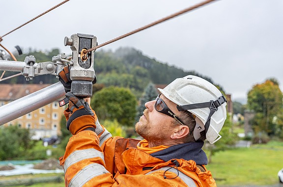 Baumaschine auf Gleisen die von einer Person bedient wird.
