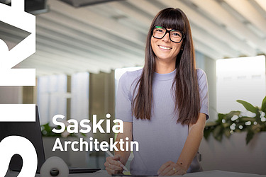 Frau steht im Büro und lächelt in die Kamera