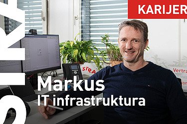 Kolega sedi za stolom i gleda u kameru