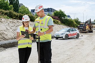 Zdjęcie kobiety i mężczyzny podczas prac geodezyjnych 