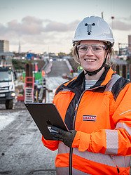 A woman on a construction site smiling in the camera