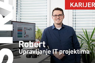 Kolega sedi za stolom i gleda u kameru