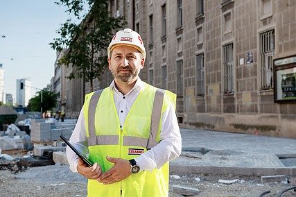 Tehnički rukovoditelj grupe u STRABAG-u Kolega na gradilištu, drži tablet u ruci i gleda u kameru