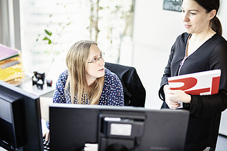 Im Traineeprogramm der STRABAG Foto Zwei Mitarbeiterinnen besprechen sich vor zwei Bildschirmen